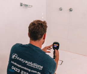 A plumber scanning the area for possible water leak.